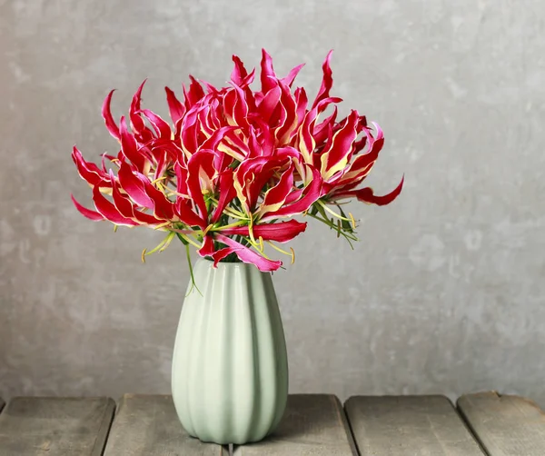 Gloriosa superba fiore su tavolo di legno . — Foto Stock