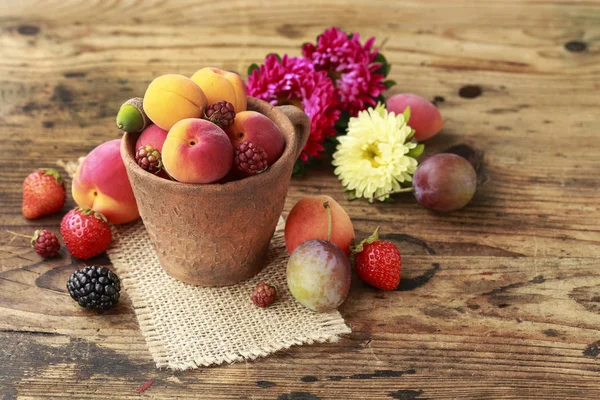 Keramisk skål med olika frukter. Trä bakgrund. — Stockfoto