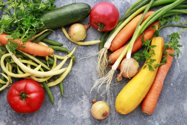 Gri taş arka planda renkli sebzeler. 