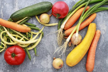 Gri taş arka planda renkli sebzeler. 