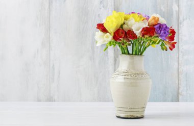 Seramik vazorenkli freesia çiçek buketi. 