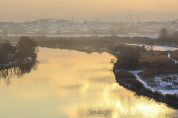 Winter sunset over the wide river. Snow on filelds — Stock Photo, Image