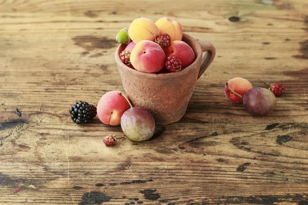 Vintage caramic mugg full av färgglada sommarfrukter — Stockfoto