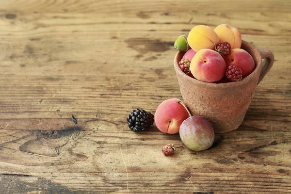 Vintage caramic mugg full av färgglada sommarfrukter — Stockfoto