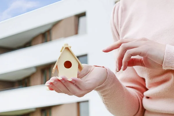 Woman holding tiny wooden house