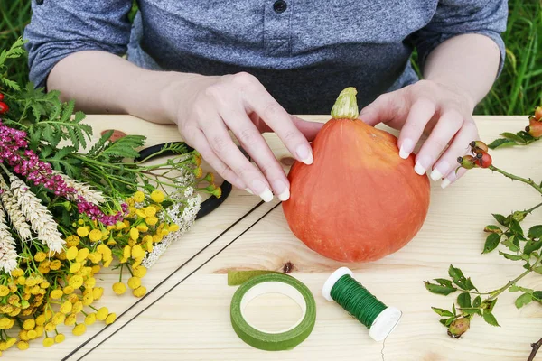 職場の花屋:野生の植物でカボチャを飾る女性. — ストック写真