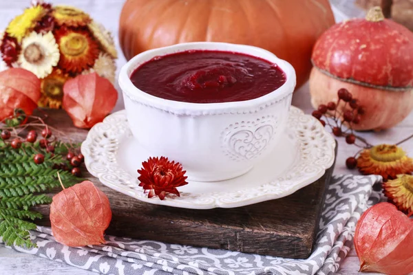 Creamy autumn soup in white plate. Seasonal pumpkin decorations — Stock Photo, Image