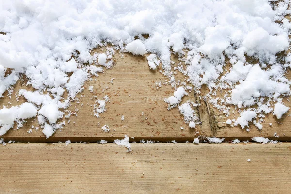 Настоящий, естественный таяние снега на деревянном фоне . — стоковое фото