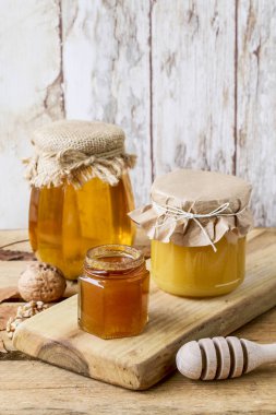 Tahta arka planda cam kavanozda bal