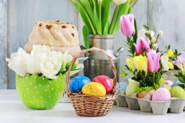 Masada Paskalya yumurtaları olan hasır sepet. Çiçek süslemeleri 