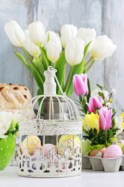Bir vintage kuş kafesi ve beyaz tuli buket içinde Paskalya yumurtaları