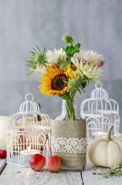 Güzel beyaz fener, çiçekler ve masada kabaklar 
