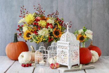 Güzel beyaz fener, çiçekler ve masada kabaklar 