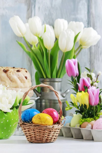 Weidenkorb mit Ostereiern auf dem Tisch. Blumenschmuck — Stockfoto