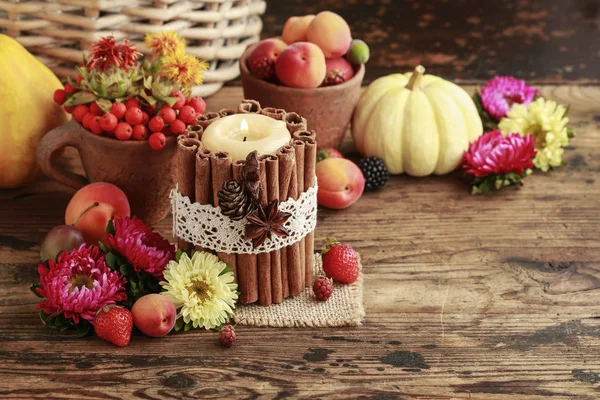 Свечи украшены корицей палочки среди осенних фруктов и фл — стоковое фото