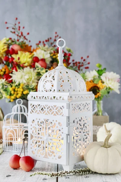 Lâmpada branca bonita, flores e abóboras na mesa — Fotografia de Stock