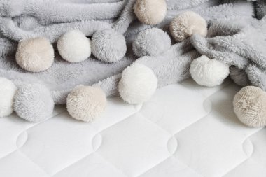 Yeni şilte üzerinde ponpon gri battaniye. 