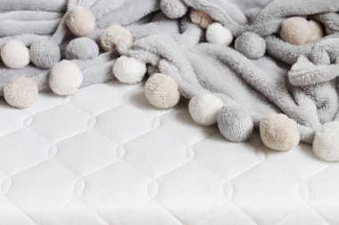 Yeni şilte üzerinde ponpon gri battaniye. 