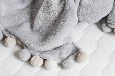 Yeni şilte üzerinde ponpon gri battaniye. 