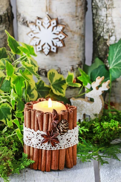 Candle decorated with cinnamon sticks, moss, ivy leaves — Stock Photo, Image