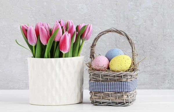 Bukiet różowych tulipanów i kosz Wielkanocnych jajek — Zdjęcie stockowe