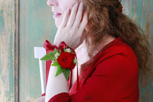 Bridesmaid wearing wrist corsage made of red rose flowers. — Stock Photo, Image