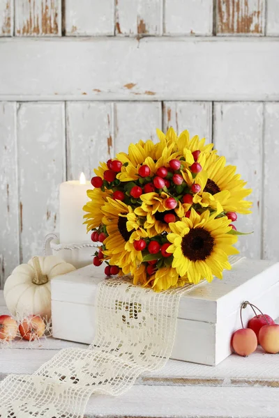 Bouquet of sunflowers and hypericum berries, candles, lace.