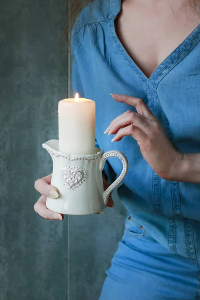 Mujer sosteniendo una vela en habitación oscura . — Foto de Stock