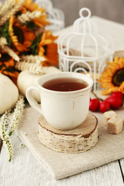 Чашка чая и красивые осенние цветочные украшения на столе . — стоковое фото