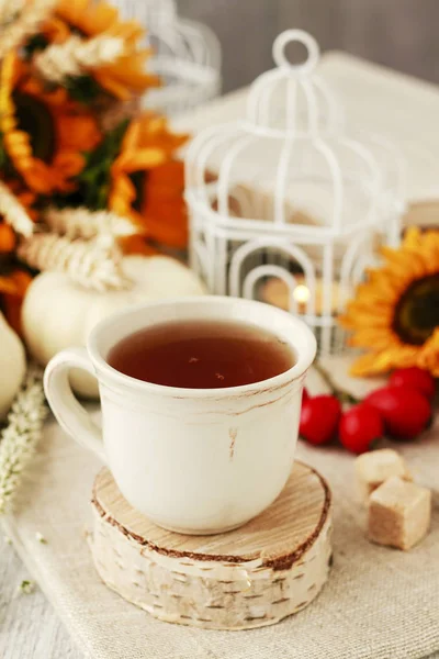 Tasse Tee und schöne herbstliche Blumendekorationen auf dem Tisch. — Stockfoto