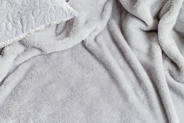 Cobertor cinza com pompons no novo colchão . — Fotografia de Stock