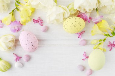 Beyaz ahşap masa üzerinde lale ler ve freesias. Flo arasında Paskalya yumurtaları