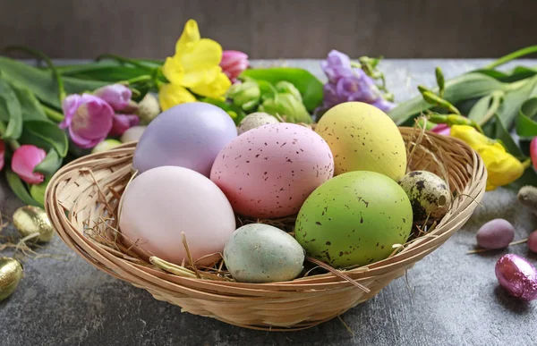 Colorful flowers and painted Easter eggs on grey, stone backgrou — Stock Photo, Image