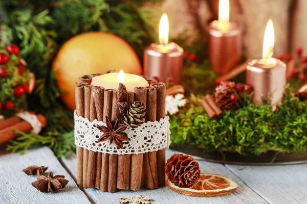 Candle decorated with cinnamon sticks. Christmas arrangement.
