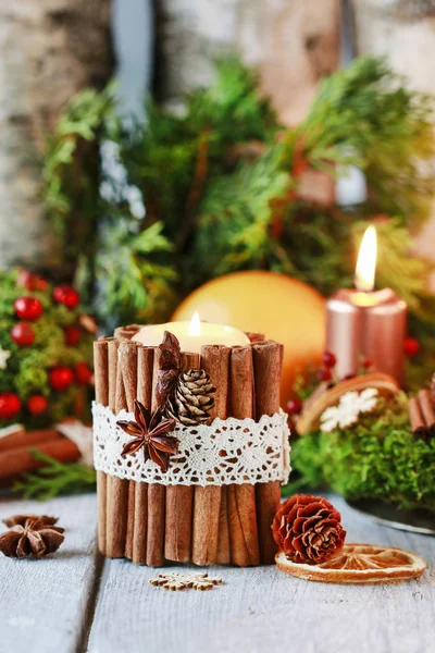 Candle decorated with cinnamon sticks. Christmas arrangement.