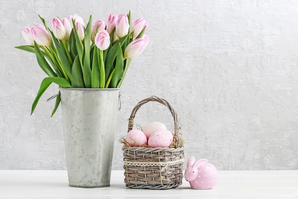 Bouquet of tulips and basket of Easter eggs — Stock Photo, Image