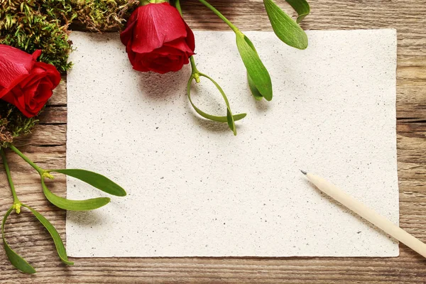 红玫瑰、 槲寄生、 苔藓和张空白的纸 — 图库照片