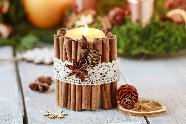 Candle decorated with cinnamon sticks — Stock Photo, Image