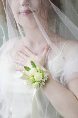 Gelin gül ve eustoma çiçekyapılmış bilek korsaj giyiyor. 