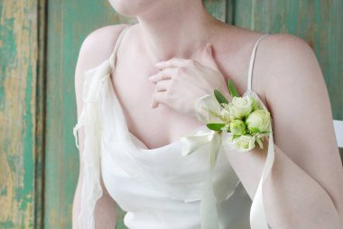 Gelin gül ve eustoma çiçekyapılmış bilek korsaj giyiyor. 