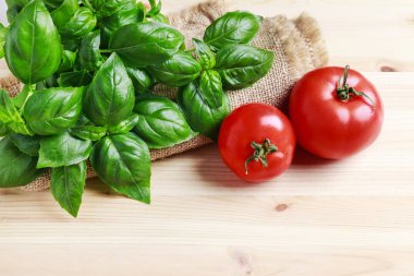 Ahşap arka planda fesleğen bitki ve kırmızı domates