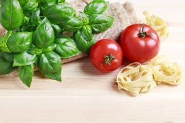 Ahşap arka planda fesleğen bitki ve kırmızı domates