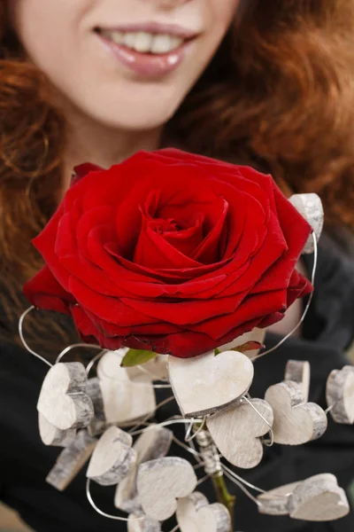 Femme tenant fleur rose rouge . — Photo