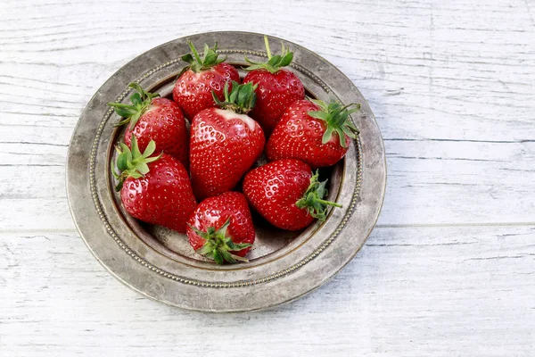 Schüssel mit Erdbeeren auf weißem Holztisch. — Stockfoto
