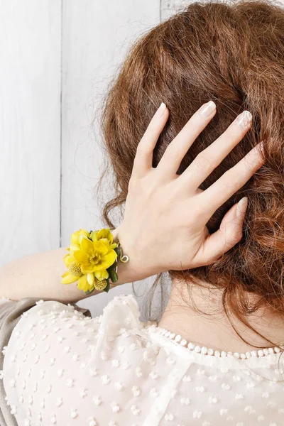 黄色い花で作られた手首のコサージュを身に着けている女性. — ストック写真
