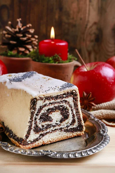 Christmas poppy seed cake and red apples around. — Stock Photo, Image