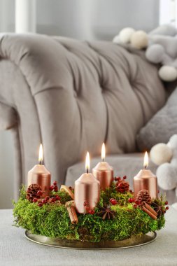 Yosun, tarçın çubukları ve rosa canina dalyapılmış Advent çelenk