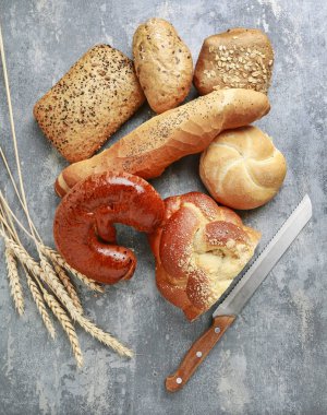 Gri taş arka plan üzerinde çeşitli çörekler.