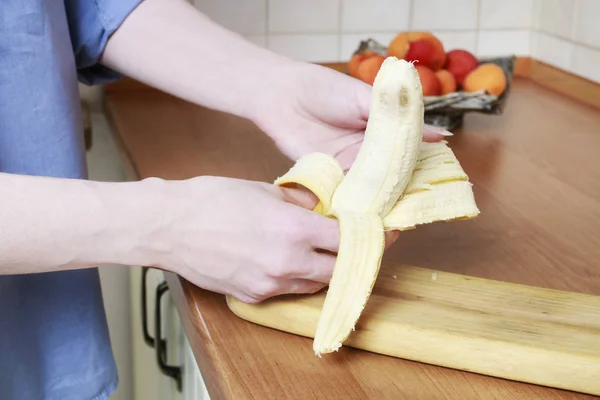 Женщина чистит банан . — стоковое фото