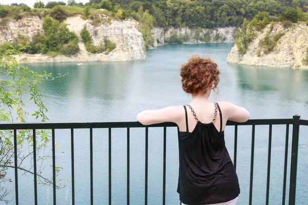 De vrouw kijkt naar het meer tussen de rotsen. — Stockfoto